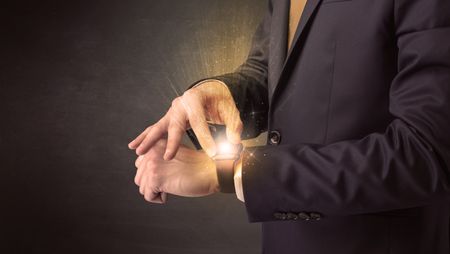 Businessman wearing smartwatch with shiny rays on it.