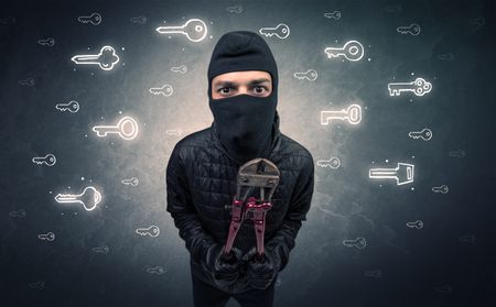 Burglar standing with tools in his hand.