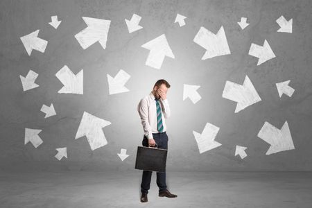 Handsome businessman standing in front of a wall with chalk drawn arrows