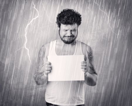 Caught gangster with rainy, grey background and black table on his hand. 