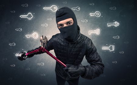Burglar standing with tools in his hand.