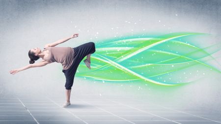 A good looking fresh street dancer dancing in front of grey background with white and bright, colorful green lines concept