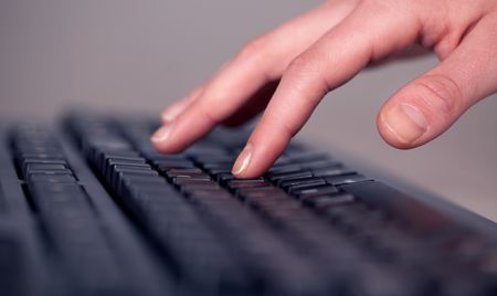 Close up of hand pressing keyboard buttons on desk