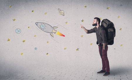 Handsome young man standing with a backpack with space related drawings in the background