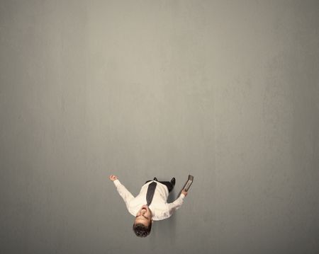 Young businessman contemplating a decision standing on a grey surface