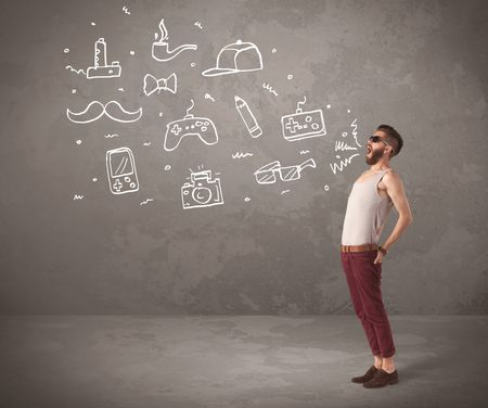 A funny hipster person in casual urban clothing shouting drawn everyday items like camera, tie or pen on city wall concept