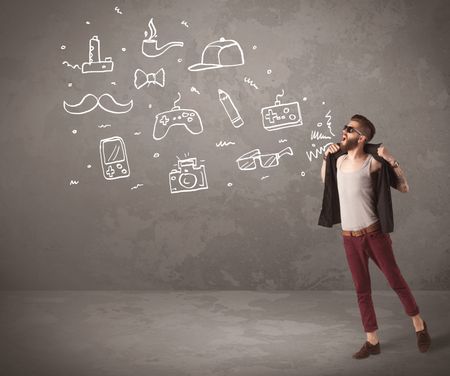 A funny hipster person in casual urban clothing shouting drawn everyday items like camera, tie or pen on city wall concept