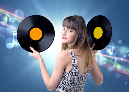 Young lady holding vinyl record on a blue background with musical notes behind her