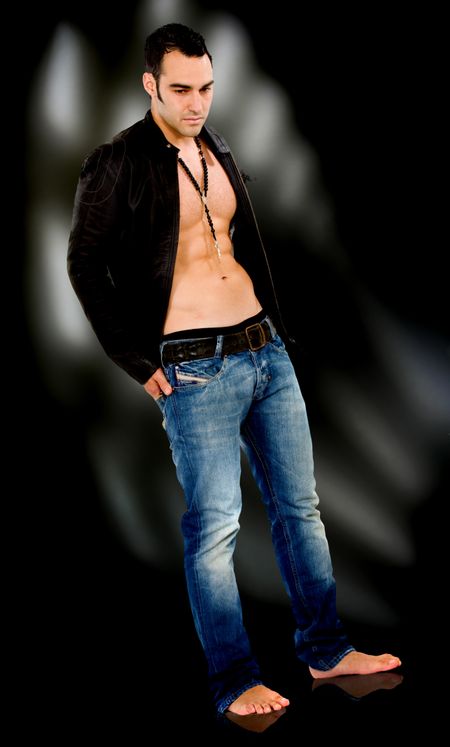 fashion male model standing looking down - over a black background