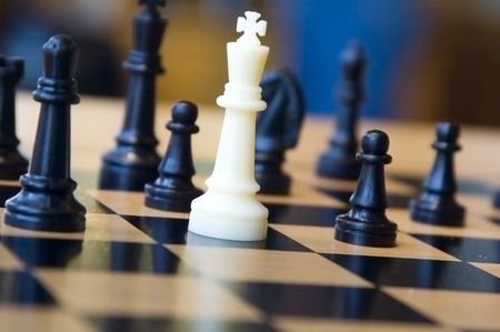 White king and black opponents on chessboard