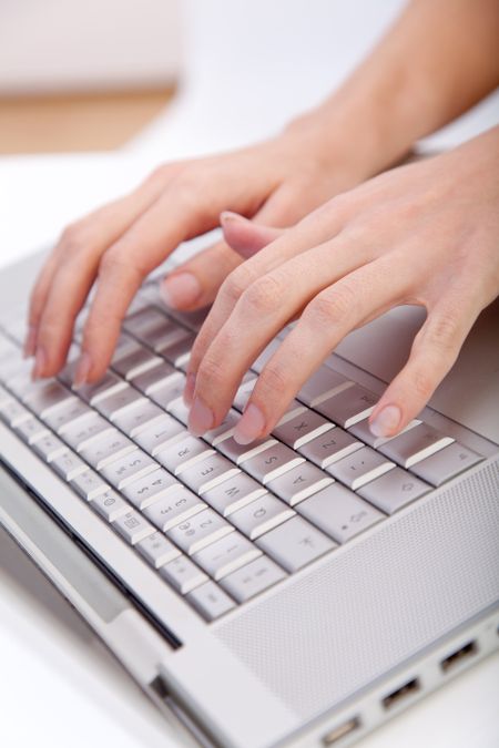 Hands typing on the keyboard of a laptop computer