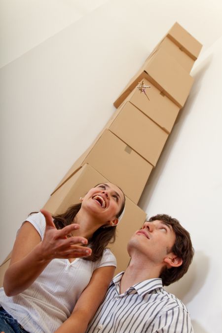 Couple with a pile of cardboard boxes from packing
