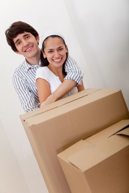 Loving couple with cardboard boxes moving to a new house