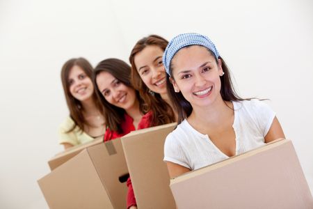 Group of girls with cardboard boxes moving into a new house.
