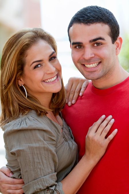 Beautiful happy couple smiling and hugging outdoors