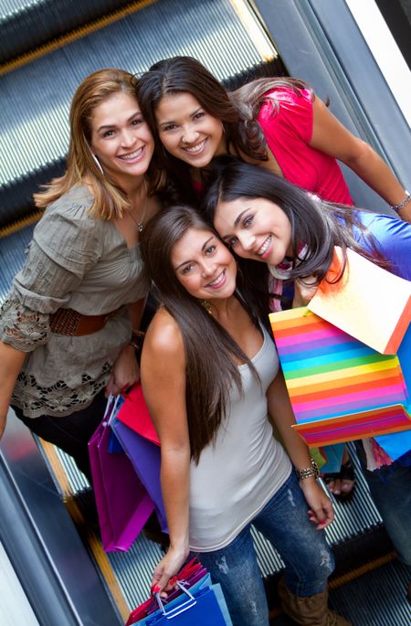 Group of shopping women with bags on the escalators