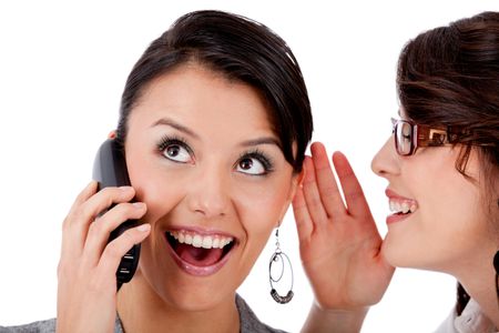 Business woman telling a secret to her co-worker while on the phone