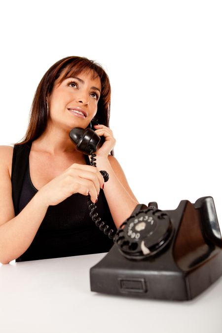 Woman talking on an old style phone - isolated over white