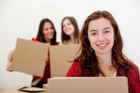 Group of girls with cardboard boxes moving into a new house