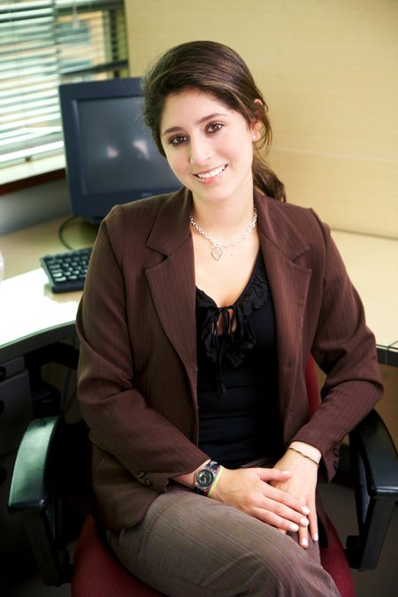 business woman in an office smiling sitting down
