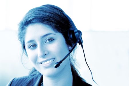customer support center woman in an office smiling - blue tones