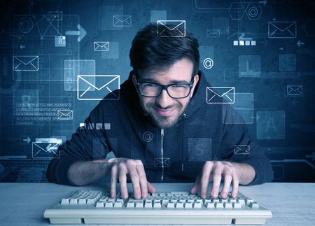 A talented young hacker hacking email address passwords concept with keyboard on desk and illustrated letters in the background