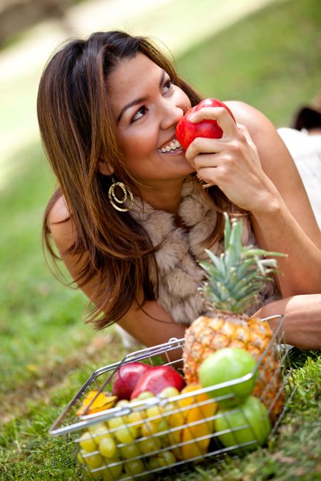 Healthy eating woman with a basket of fruits ? outdoors