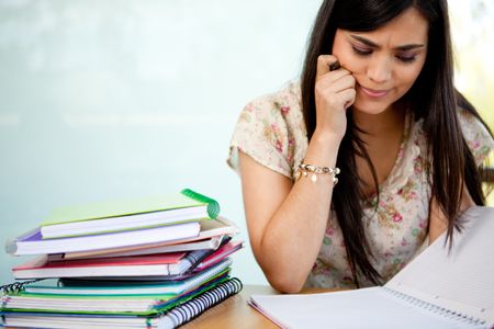 Confused female student with a pile of notebooks