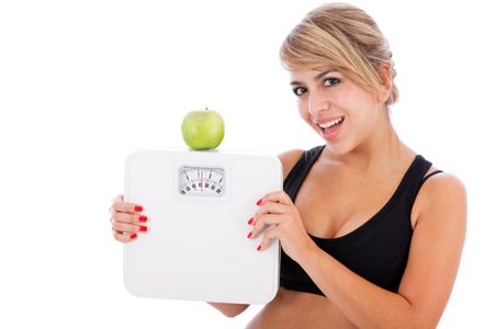 Woman trying to lose weight holding a scales and an apple