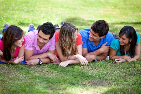 Happy group of casual friends lying outdoors