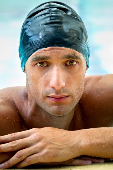 Male swimmer wearing a swimming hat at the pool