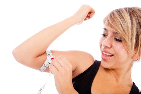 Fit woman measuring her arm ? lose weight concepts
