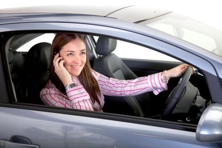 female driver smiling and talking on a mobile phone