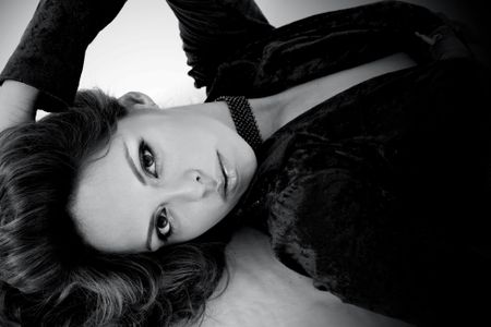 fashion woman in black and white lying on a bed