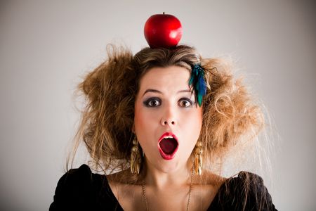 Surprised woman with a messy hairdo and an apple on top