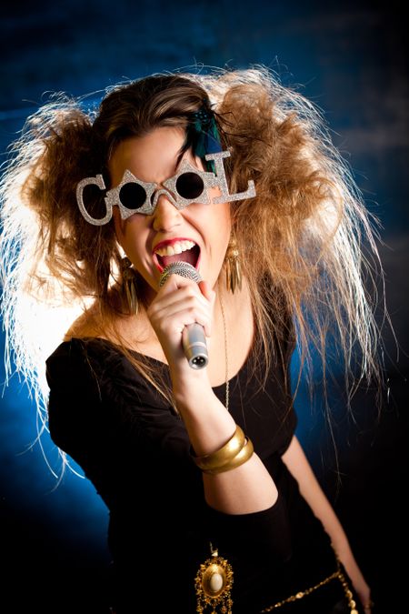 Rocker woman with messy hairdo singing with a microphone
