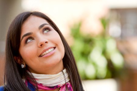 Portrait of a beautiful thoughtful woman smiling outdoors