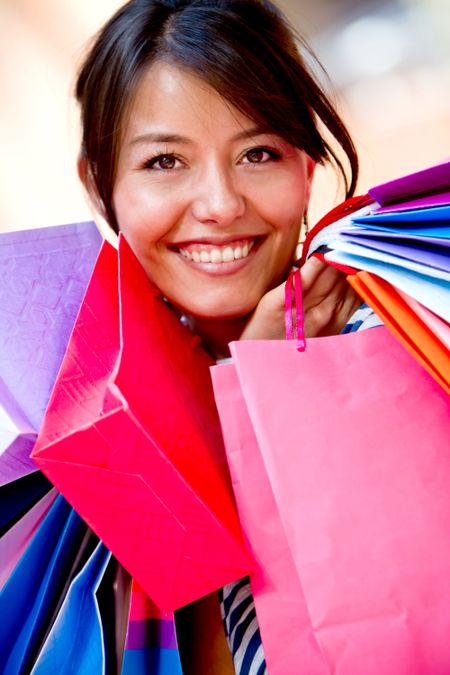 Beautiful shopping woman holding bags at a mall