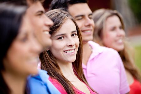 Woman standing out from a group of people and smiling