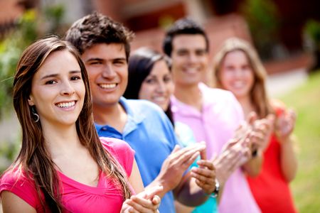 Group of happy casual friends applauding outdoors