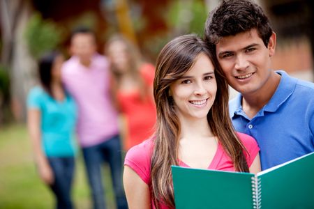 Couple of students with a notebook outdoors