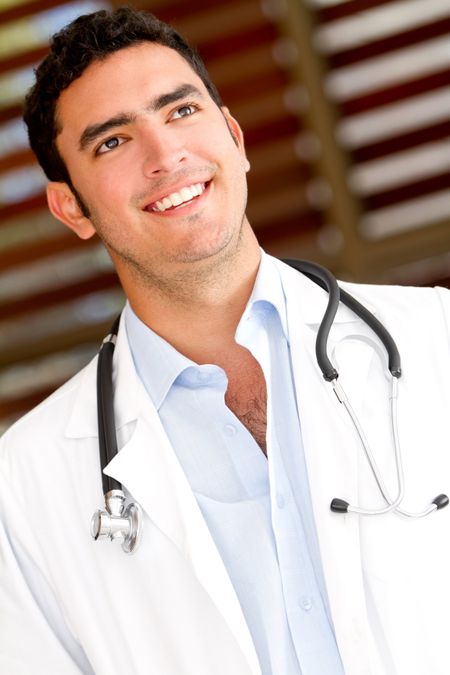 Friendly male doctor smiling at the hospital