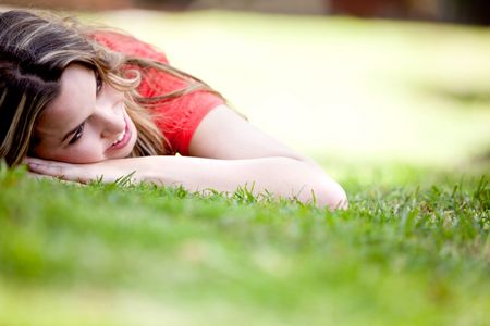 Beautiful girl lying on the floor outdoors and smiling