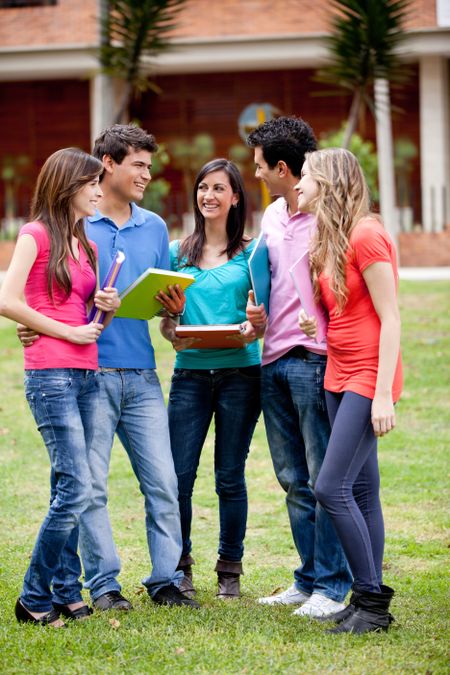 Group of students talking and holding notebooks outdoors