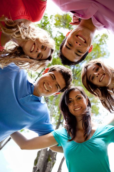 Happy group of friends hugging and smiling outdoors