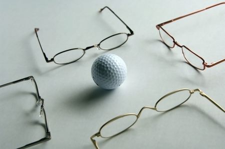 Golf ball surrounded by reading glasses