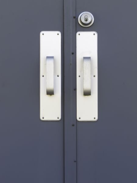Pair of silver doorhandles and keylock on exterior metallic door