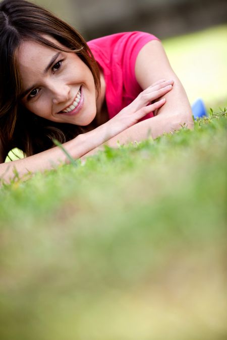 Beautiful girl lying on the floor outdoors and smiling