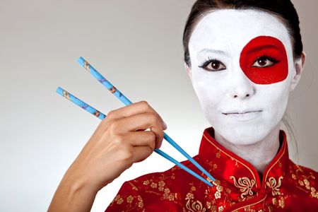 Japanese woman with chopsticks and the flag painted on her face