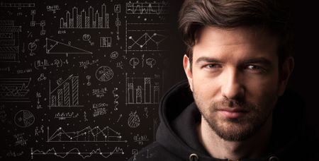 Portrait of a young businessman with charts and graphs scribbled next to him on a dark background